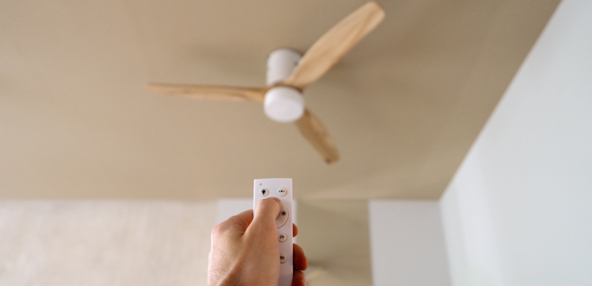 Una mano encendiendo el ventilador de techo