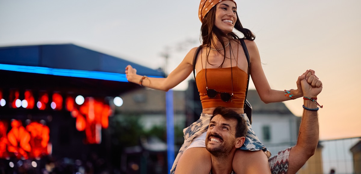 Chica sobre los hombros de un chico en un festival