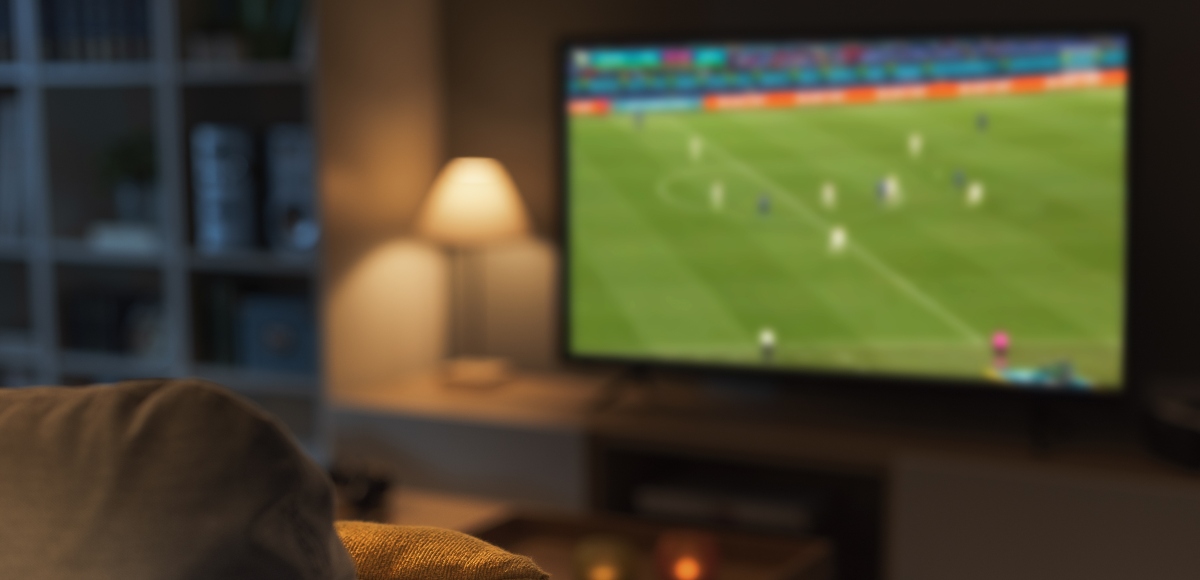 Salón con la televisión encendida mientras se ve un partido