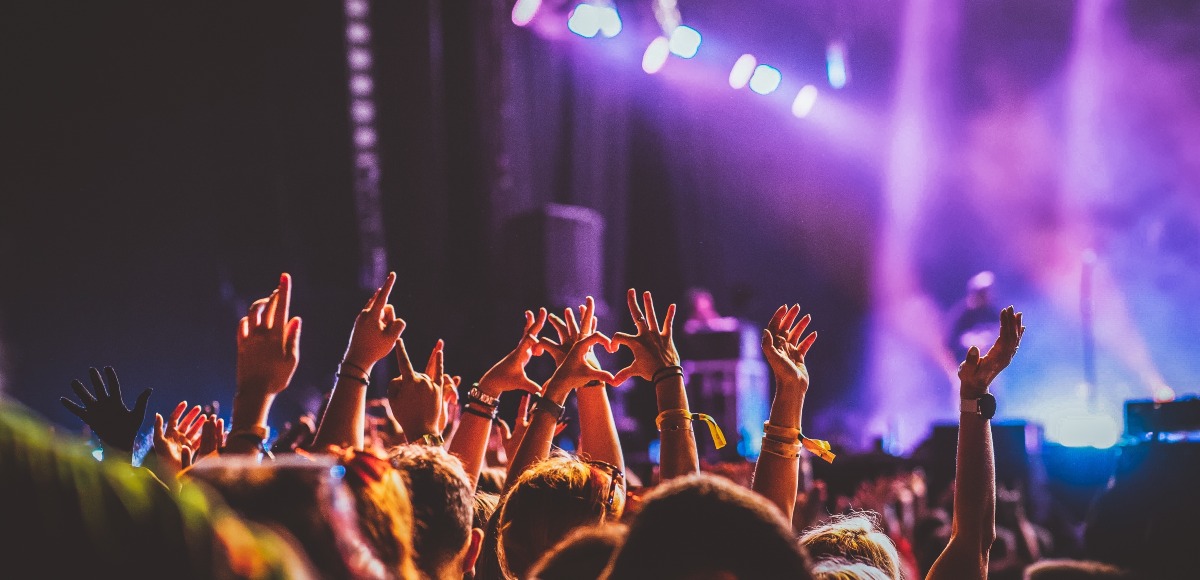 Personas levantando las manos en un concierto
